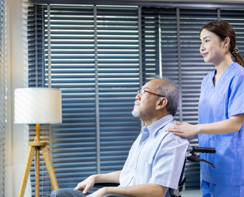 Comfort Home Care Services caregiver assisting an elderly man in a wheelchair while looking out the window at home