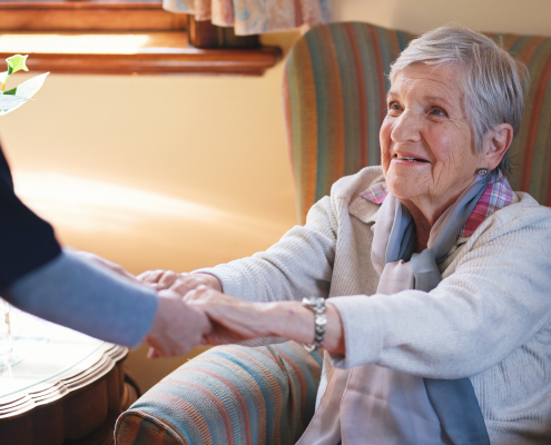 caregiver helping senior woman at home supported living vs domiciliary care concept