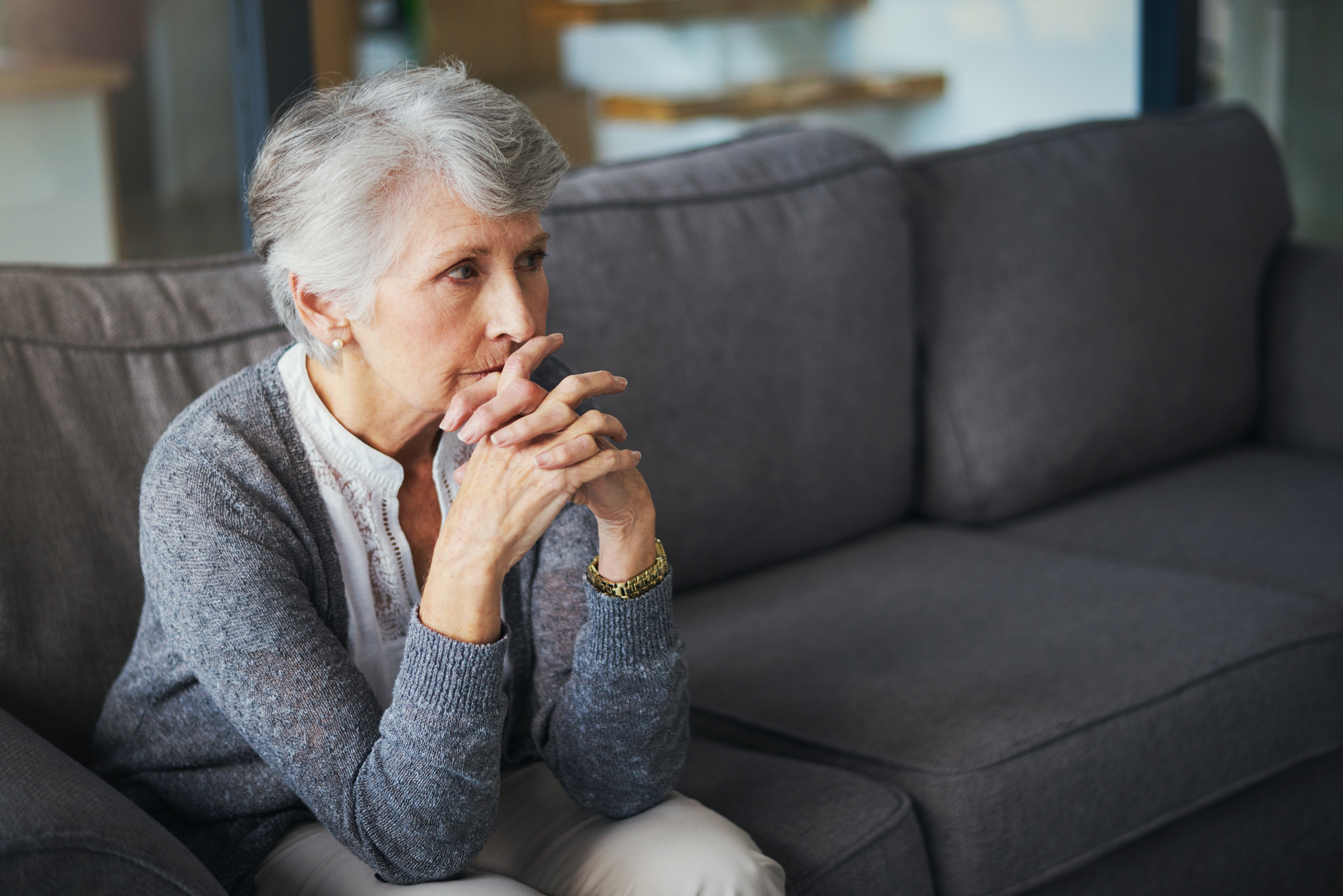 A carer providing support for elderly living at home, sitting with an older woman in her living room in Lancashire